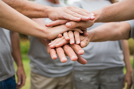 photo of many hands of volunteers on top of each other