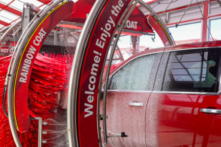 Red truck going though tommy's express car wash
