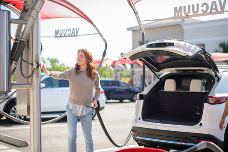Woman using vacuums at Tommy's Express Car Wash