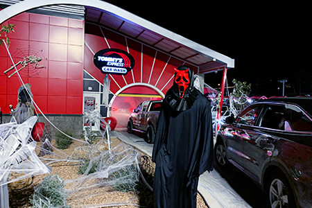 person in black halloween costume at tommy's express car wash
