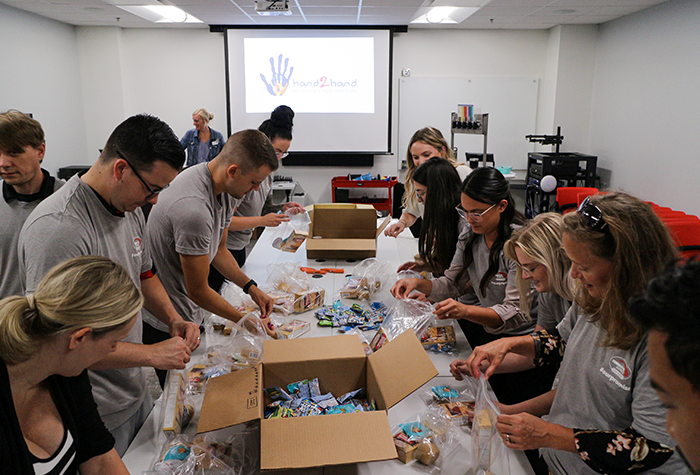 Tommy's Express volunteers packing lunches with Hand2Hand